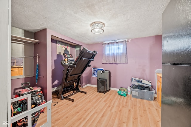 workout room featuring a textured ceiling and light hardwood / wood-style flooring