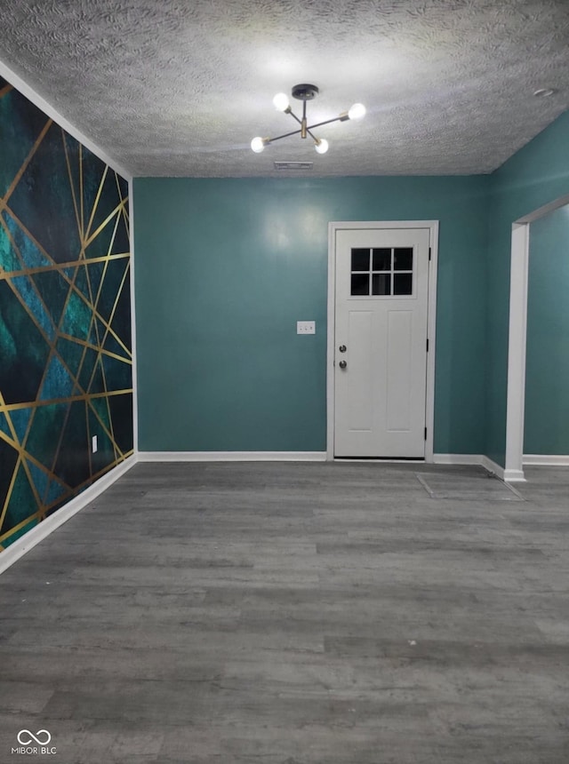 entrance foyer with a textured ceiling, an inviting chandelier, and wood-type flooring