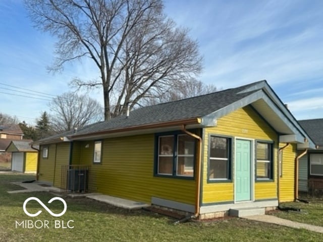 view of front of house with central air condition unit and a front yard