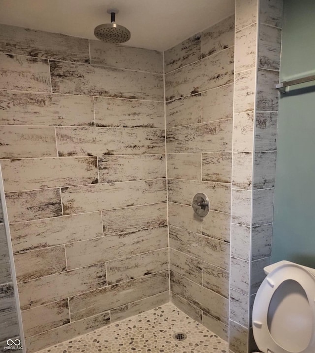 bathroom featuring toilet and tiled shower