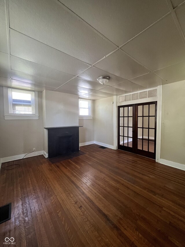 basement featuring a paneled ceiling, french doors, and wood-type flooring