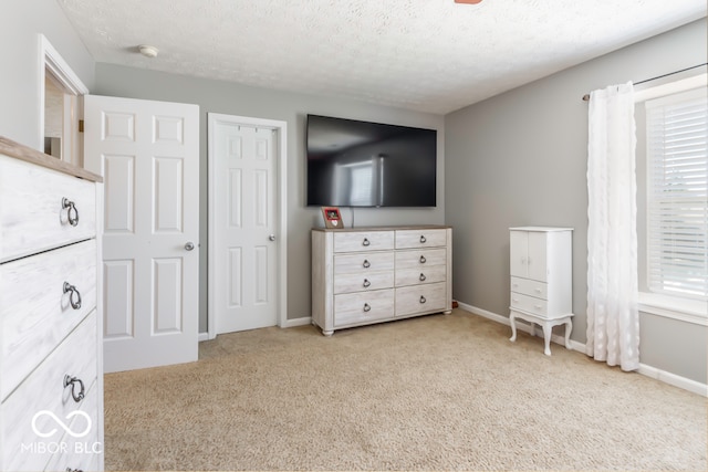 unfurnished bedroom with a textured ceiling, multiple windows, and light carpet