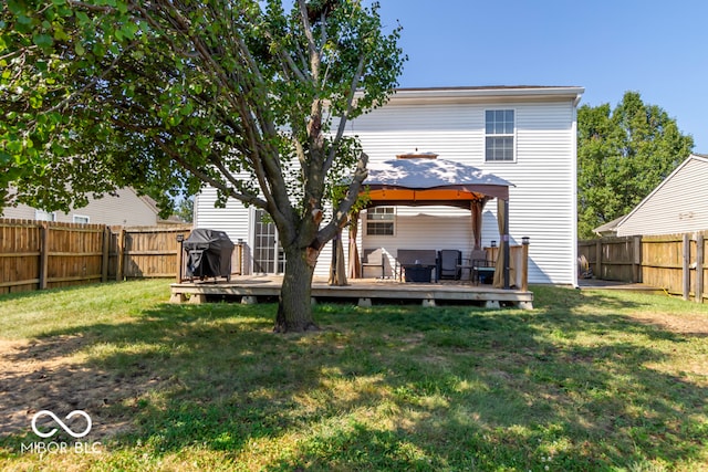 back of property with a gazebo, a deck, and a yard