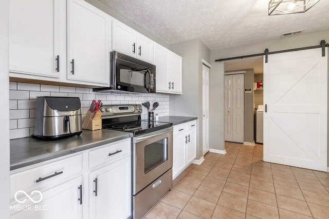 kitchen with decorative backsplash, stainless steel range with electric stovetop, white cabinetry, and a barn door