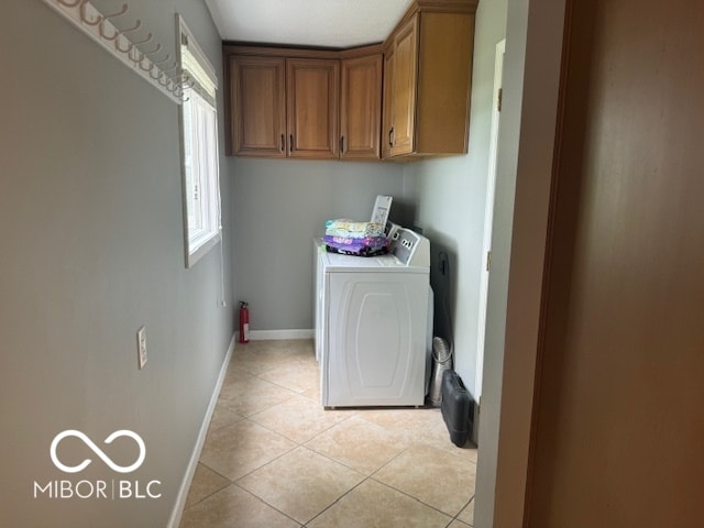 laundry area featuring cabinets, separate washer and dryer, and light tile patterned floors