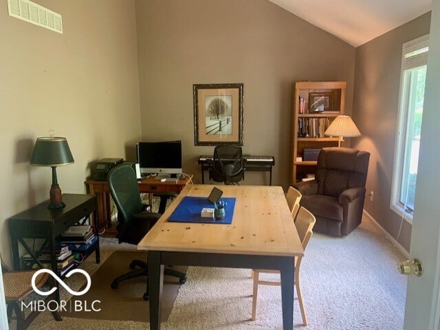 home office with lofted ceiling and carpet flooring