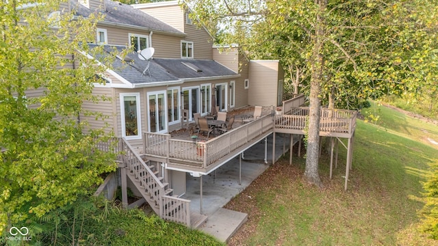 rear view of house featuring a yard, a wooden deck, and a patio