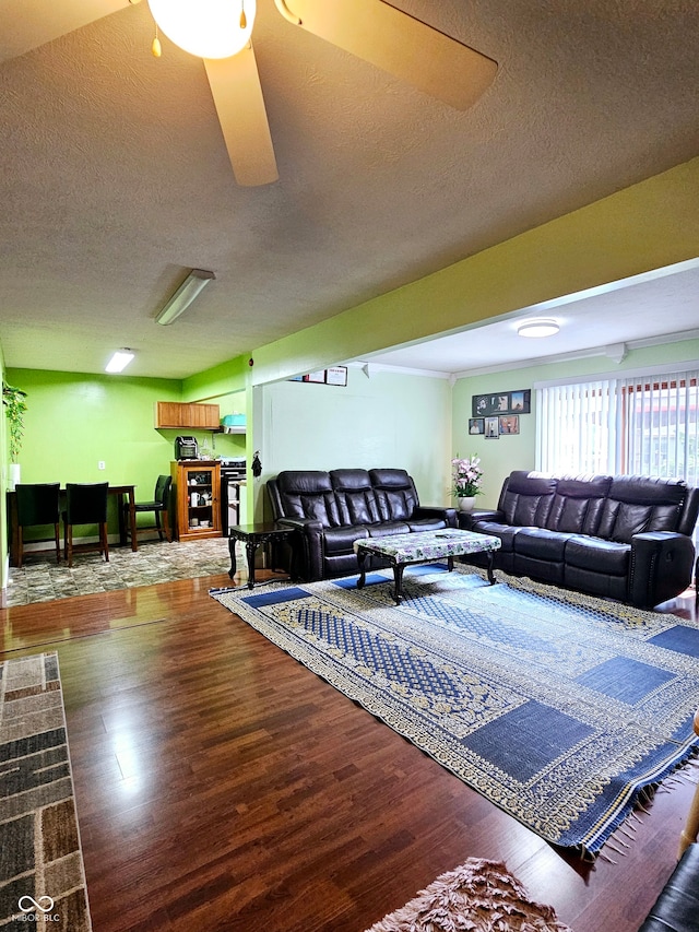 living room with a textured ceiling, ceiling fan, and hardwood / wood-style flooring