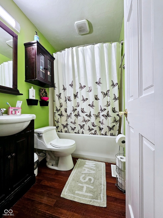 full bathroom featuring shower / bath combination with curtain, toilet, hardwood / wood-style floors, and vanity