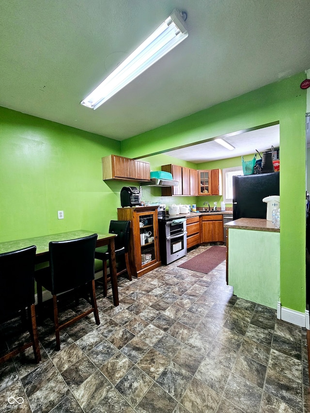 kitchen with black fridge, electric range, and dark tile patterned floors