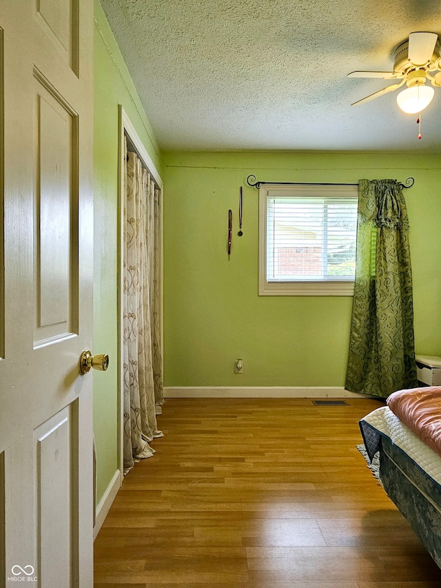 interior space featuring a textured ceiling, light hardwood / wood-style flooring, and ceiling fan