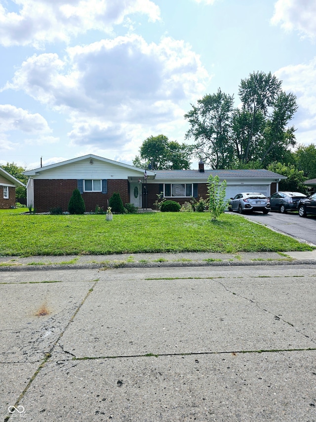 ranch-style house featuring a front lawn and a garage