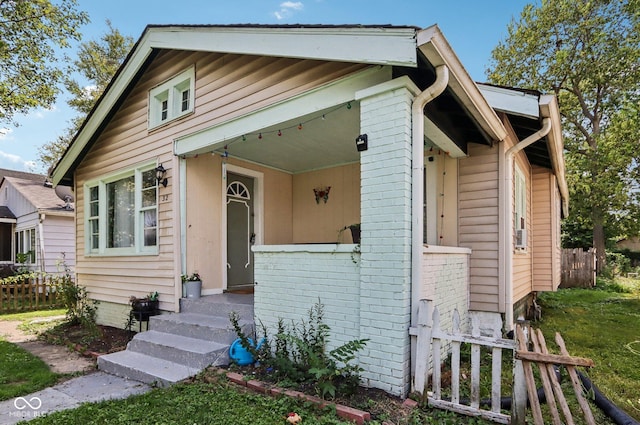 bungalow-style house with fence and brick siding