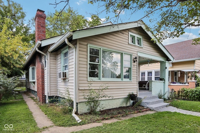 bungalow-style house with a front lawn and a chimney