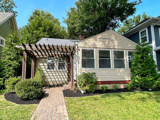 view of front of property with a front lawn and a pergola