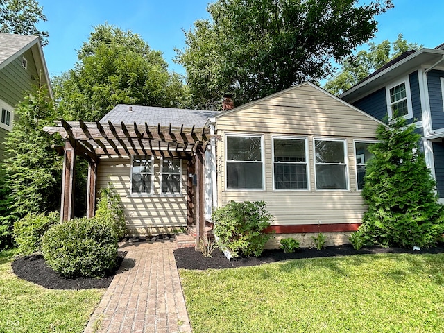 view of front of property with a pergola and a front yard