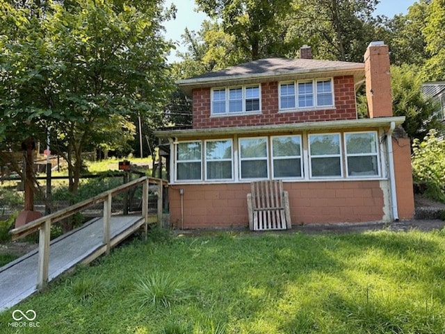 exterior space with concrete block siding, a chimney, and a front lawn