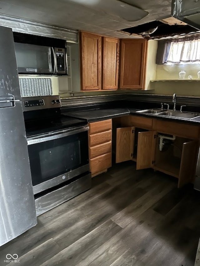 kitchen featuring appliances with stainless steel finishes, sink, and dark hardwood / wood-style floors