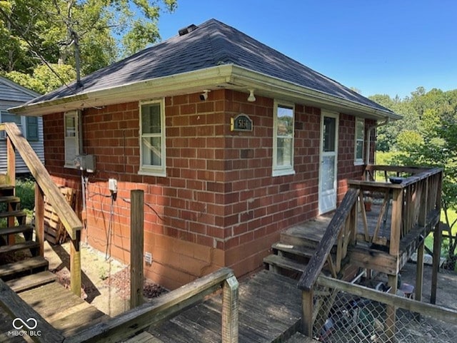 view of side of property with brick siding and a deck