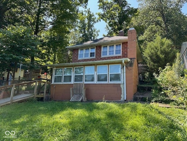 view of front facade featuring a chimney and concrete block siding