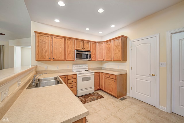 kitchen with light tile patterned floors, electric range, kitchen peninsula, and sink