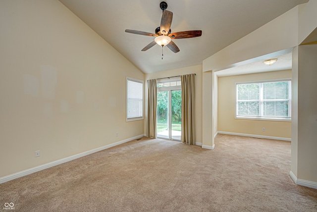 carpeted empty room with vaulted ceiling and ceiling fan