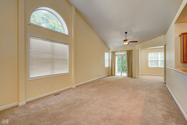 unfurnished living room with high vaulted ceiling, ceiling fan, and light colored carpet