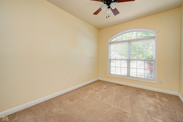 carpeted spare room featuring vaulted ceiling, a healthy amount of sunlight, and ceiling fan