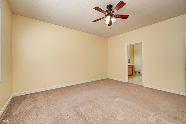 carpeted spare room featuring a textured ceiling and ceiling fan