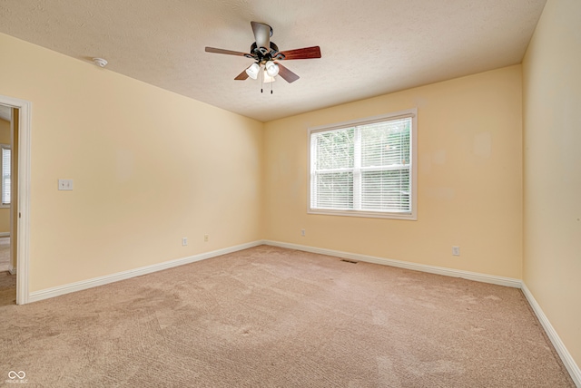 carpeted empty room featuring a textured ceiling and ceiling fan