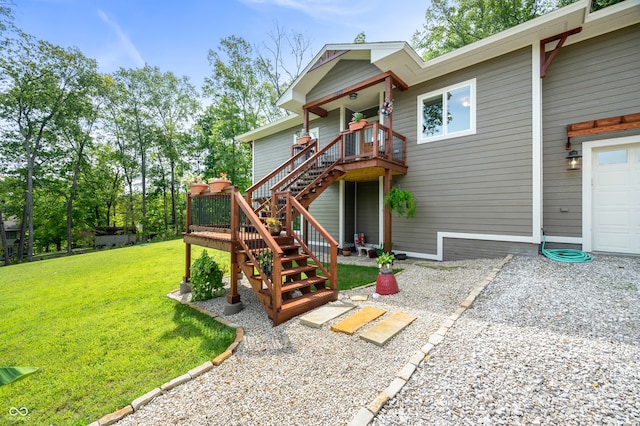 rear view of property featuring a lawn, a garage, and a deck