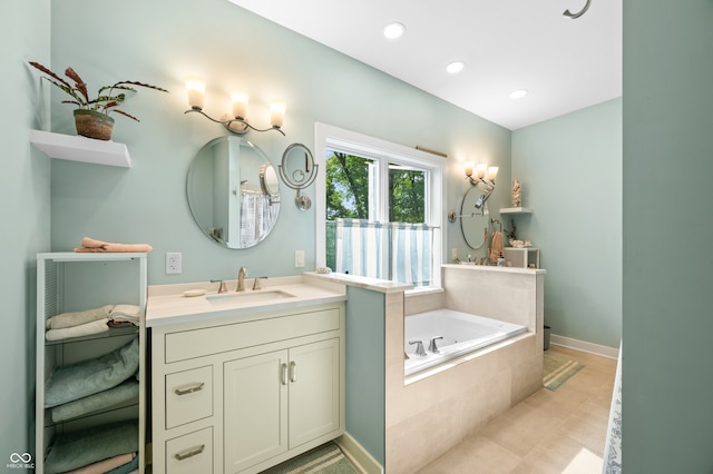 bathroom featuring vanity, a relaxing tiled tub, and tile patterned floors