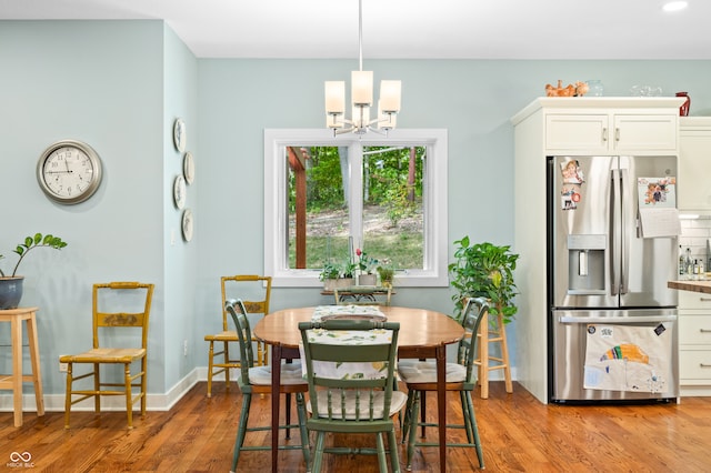 dining room featuring light wood-type flooring and a chandelier