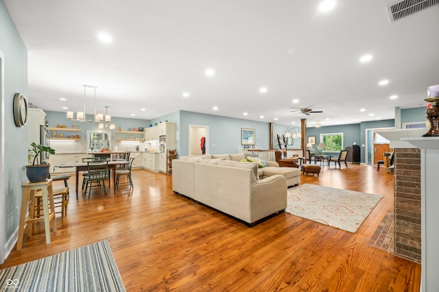 living room featuring light hardwood / wood-style flooring and ceiling fan