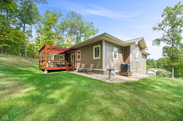 rear view of property with a wooden deck and a lawn