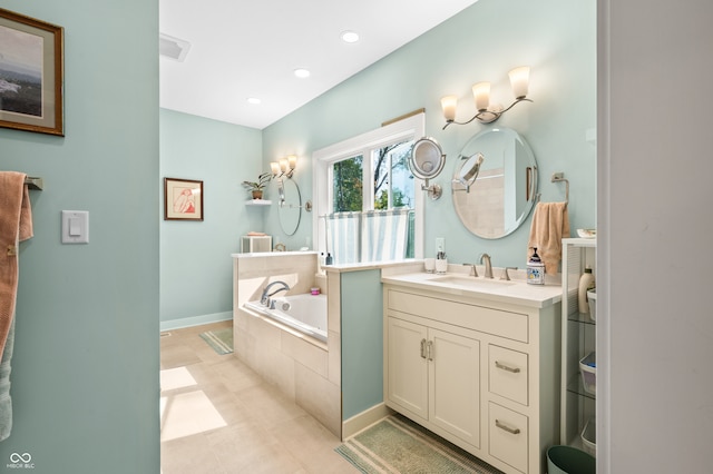 bathroom with vanity, tiled tub, and tile patterned floors