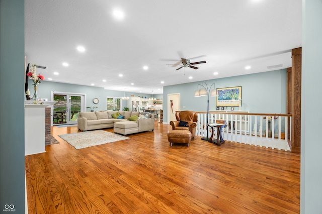 living room featuring light wood-type flooring and ceiling fan