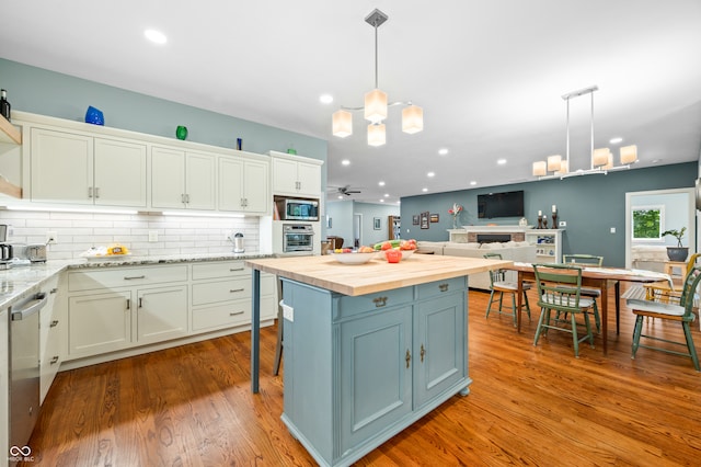 kitchen with light hardwood / wood-style flooring, wood counters, hanging light fixtures, and a kitchen island