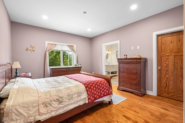 bedroom featuring light hardwood / wood-style floors and ensuite bath