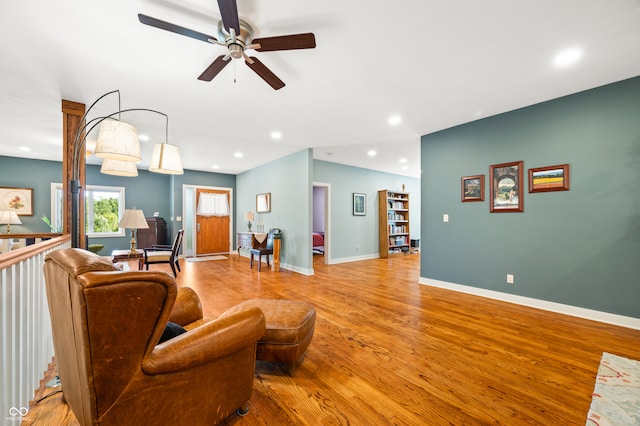 living room with light hardwood / wood-style flooring and ceiling fan