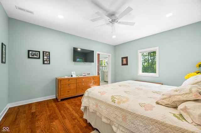 bedroom featuring dark wood-type flooring, ceiling fan, and ensuite bath