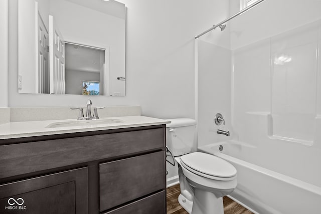 full bathroom featuring wood-type flooring, vanity, shower / tub combination, and toilet