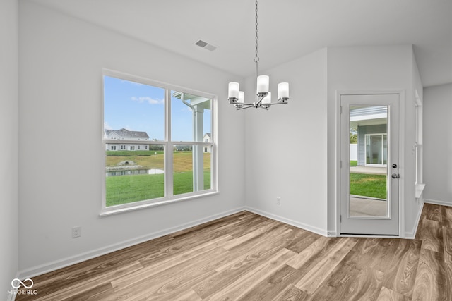 unfurnished dining area featuring hardwood / wood-style floors and a notable chandelier