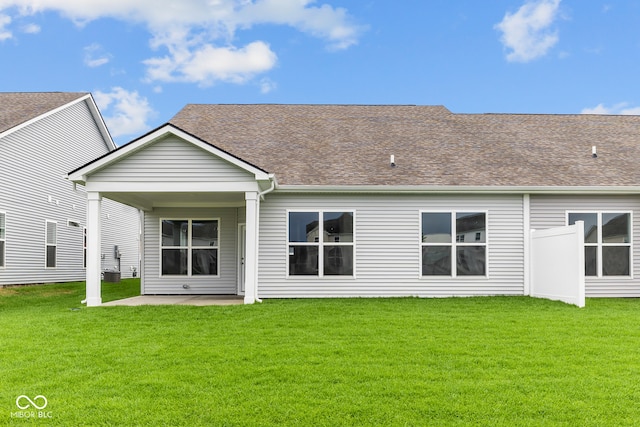 rear view of property with a yard and a patio area