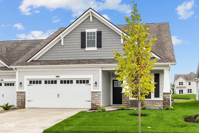 craftsman house featuring a garage and a front lawn