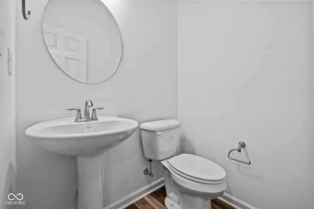 bathroom featuring wood-type flooring and toilet