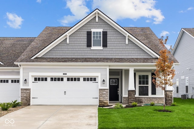 craftsman house featuring a front yard, covered porch, and central air condition unit