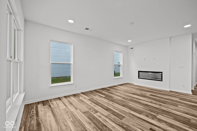 unfurnished living room featuring hardwood / wood-style floors and a wealth of natural light