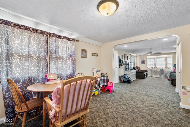 carpeted dining area featuring ceiling fan and a textured ceiling