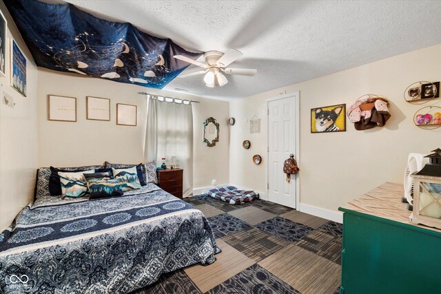 bedroom with ceiling fan, wood-type flooring, and a textured ceiling